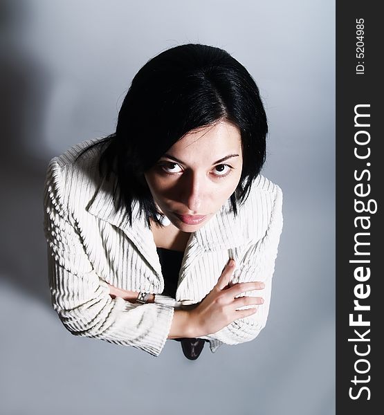 A high-key portrait about a young pretty lady with black hair who is looking up and dreaming. She is wearing a white coat and a black dress. A high-key portrait about a young pretty lady with black hair who is looking up and dreaming. She is wearing a white coat and a black dress.