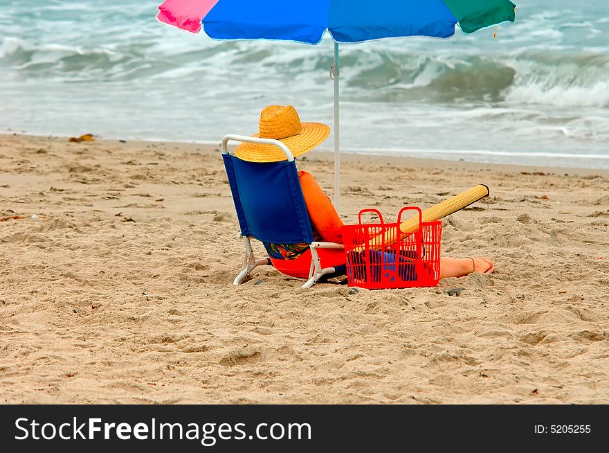 A woman sitting in a lounge chair at the beach watching waves. A woman sitting in a lounge chair at the beach watching waves.