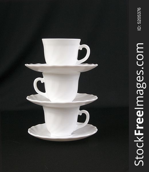 A stack of cups and saucers on the black background. A stack of cups and saucers on the black background