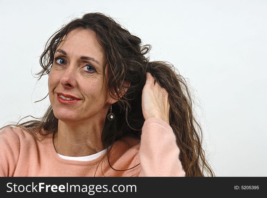 Attractive middle-aged caucasian woman with long brown hair, in a pink sweater. Attractive middle-aged caucasian woman with long brown hair, in a pink sweater.