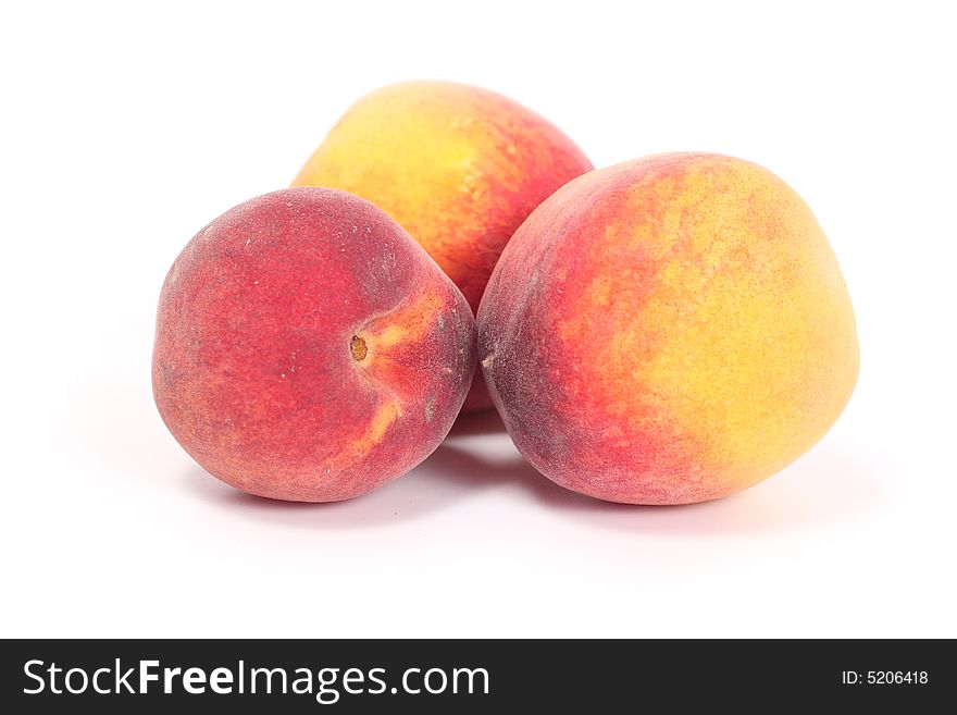 Three tasty juicy peaches on a white background