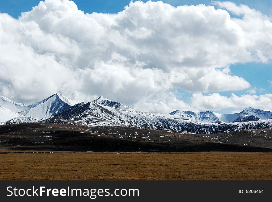The thick white clouds in the blue sky,continous and undulating mountains,Rikeze,Tibet,China. The thick white clouds in the blue sky,continous and undulating mountains,Rikeze,Tibet,China.