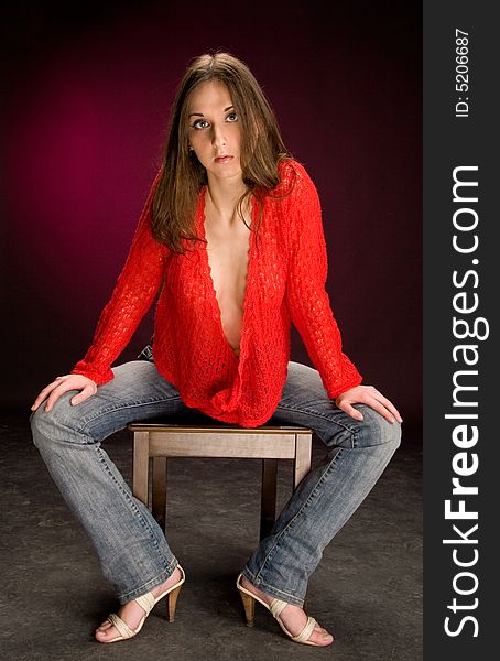 Girl sit on stool. drark red background