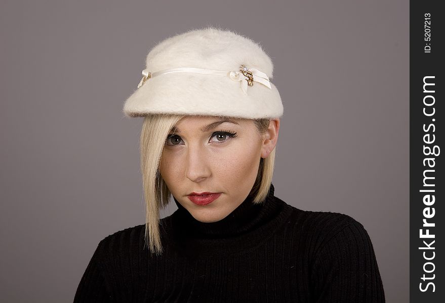 A blonde in a white fur hat with nice eyes. A blonde in a white fur hat with nice eyes