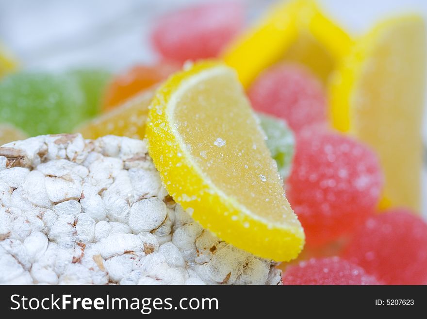 Small loaf of bread and heap of colorful dried sugared fruits. Small loaf of bread and heap of colorful dried sugared fruits