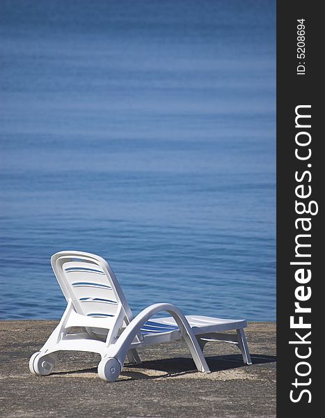 Plastic beach chair at the edge of a sea