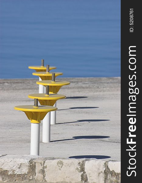 Umbrella holders on a terrace next to a sea