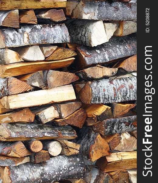 A pile of reddish wood with bark. A pile of reddish wood with bark