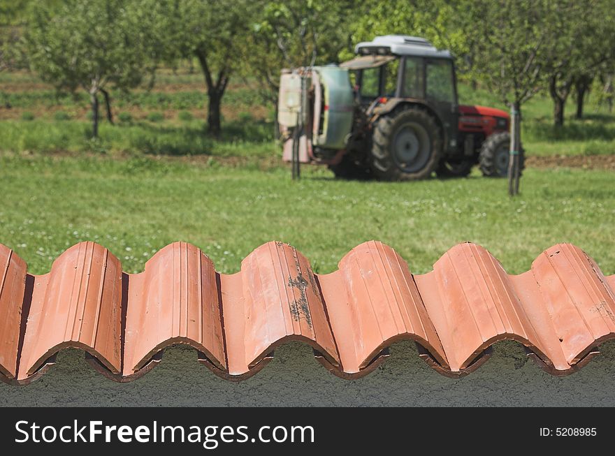 Agricultural tractor photographed from behind a garden wall
