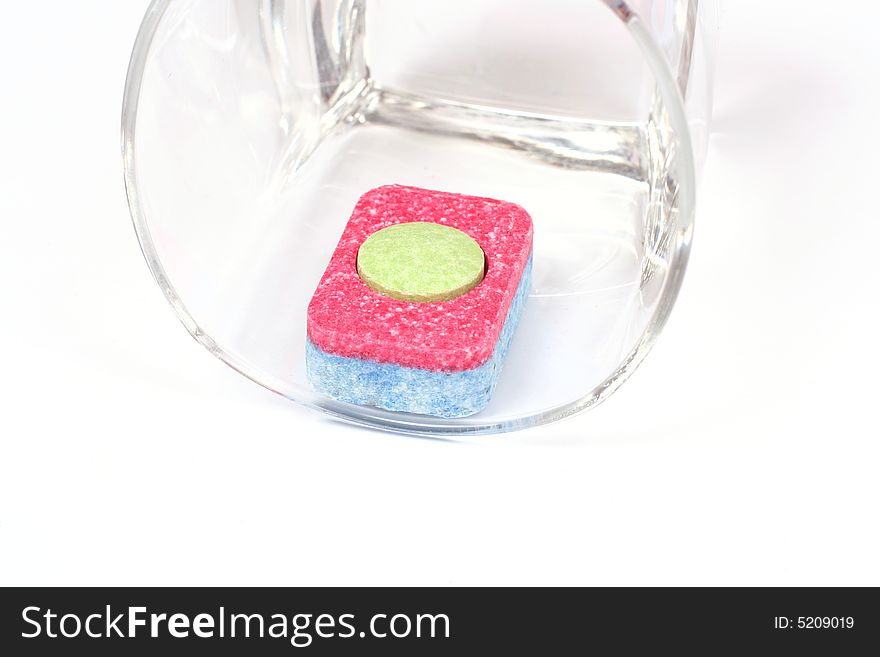 Colorful isolated dishwasher tablet in a glass