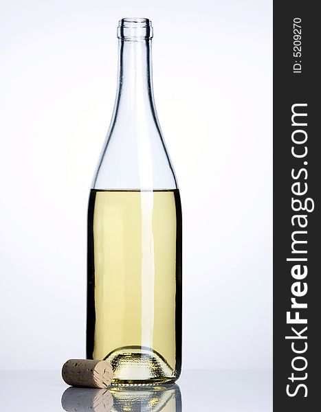 Opened bottle of white wine with cork on white backround