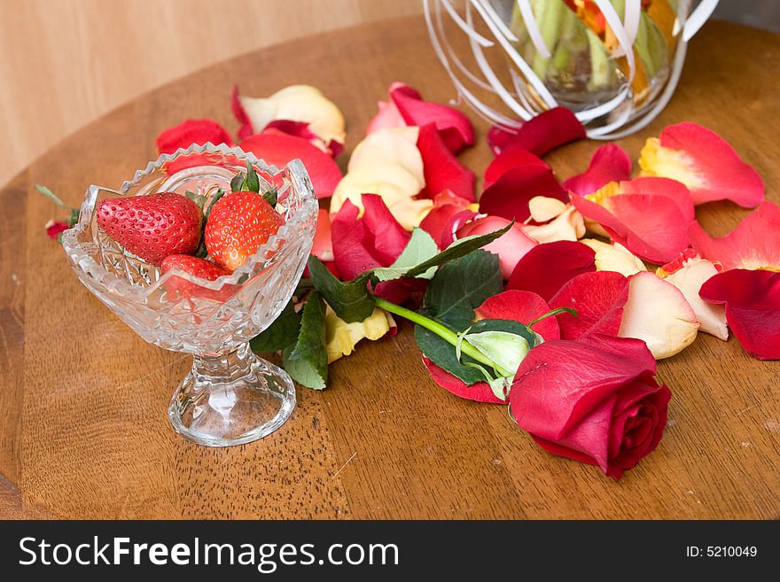 Beautiful red tulip petals ans strawberry in bowl on the table. Beautiful red tulip petals ans strawberry in bowl on the table
