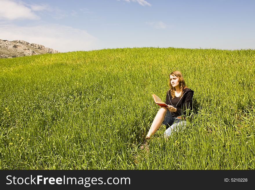 Blond woman reading over the grass. Blond woman reading over the grass