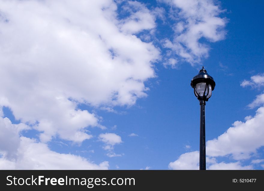 A single English style lamp with a cloudy blue sky behind. A single English style lamp with a cloudy blue sky behind.