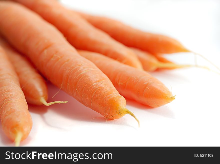 A bunch of fresh organic carrots, on a white background.