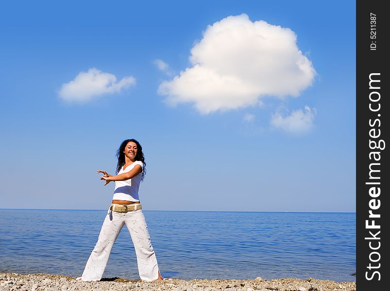 Young beautiful woman doing fitness exercises in the sea