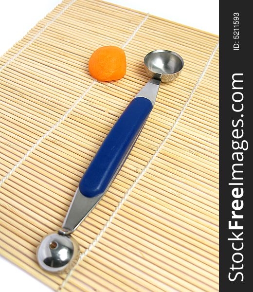 Noisette potato cutter with a rounded carrot on a bamboo mat. Noisette potato cutter with a rounded carrot on a bamboo mat