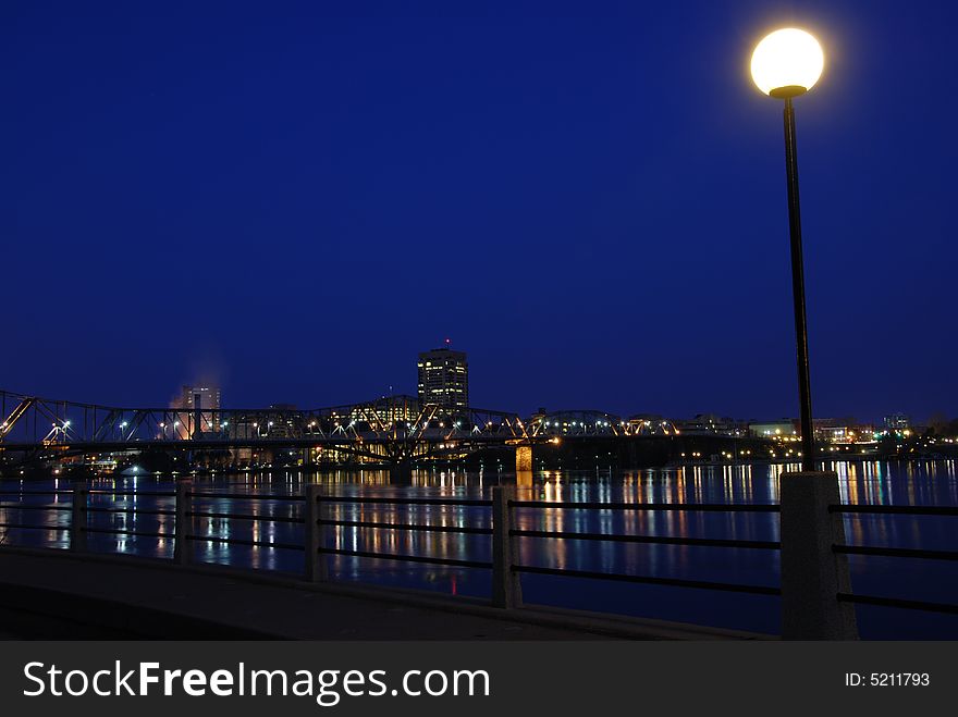 A lamp post lights up the sidewalk along the Ottawa River.  The smoke on the left is coming from the Scott Paper plant. A lamp post lights up the sidewalk along the Ottawa River.  The smoke on the left is coming from the Scott Paper plant.