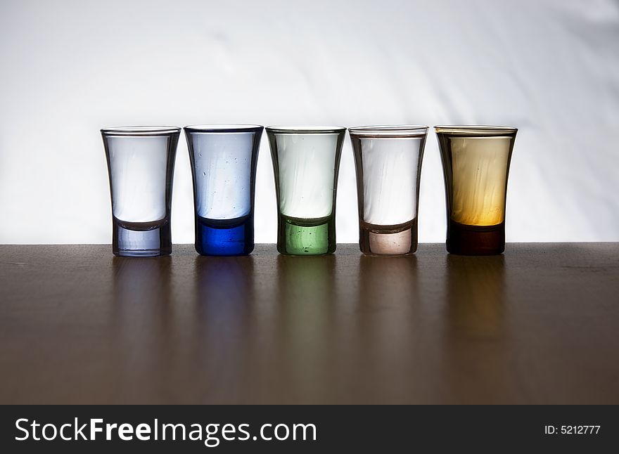 Five shots of alcohol with reflexion in the table