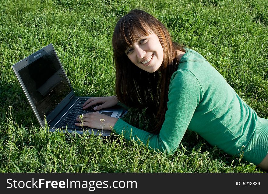 Smiling girl with laptop outdoor