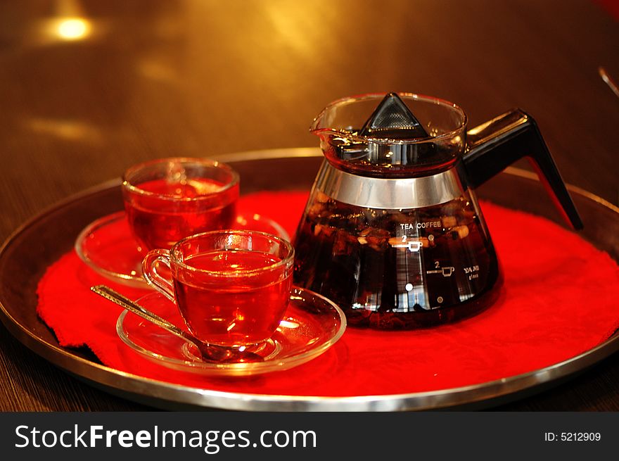 Prepared red tea in teapot an tea cups.