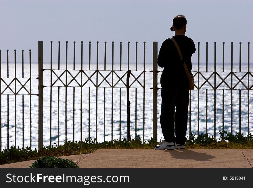 Young man taking photo at the Mediterranean Sea