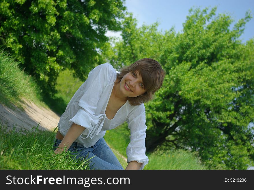 A young attractive woman sitting in a path on a warm summer day