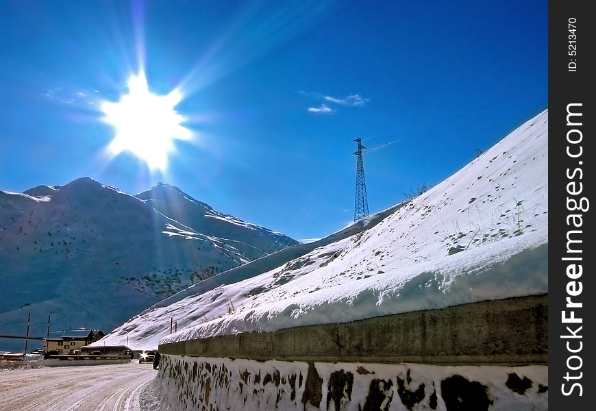 The sun is shining over a mountain full of white snow. The sun is shining over a mountain full of white snow