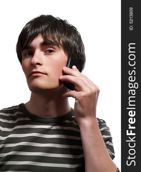 A portrait about a trendy handsome guy who is speaking with somebody by mobile phone and he has a glamorous look. He is wearing a striped t-shirt.