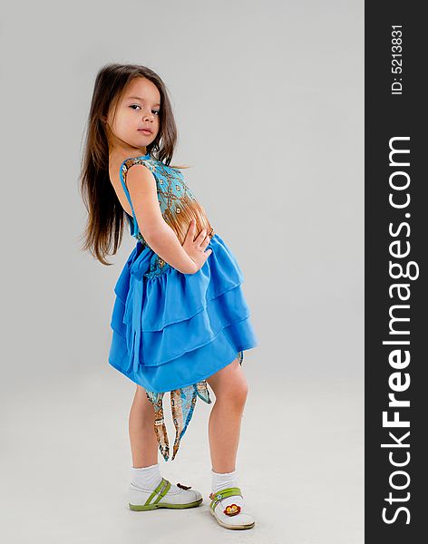Little cute girl posing in a fancy blue dress. Little cute girl posing in a fancy blue dress