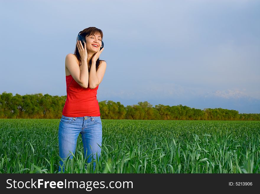 Young Woman With Headphones In A Wheat Field