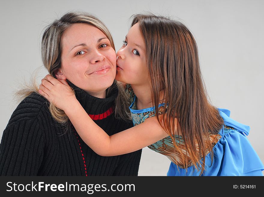 Cute little baby girl kissing her mom with love. Cute little baby girl kissing her mom with love