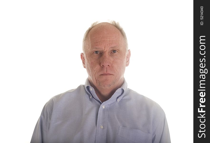 An older man in a blue dress shirt with a serious look. An older man in a blue dress shirt with a serious look