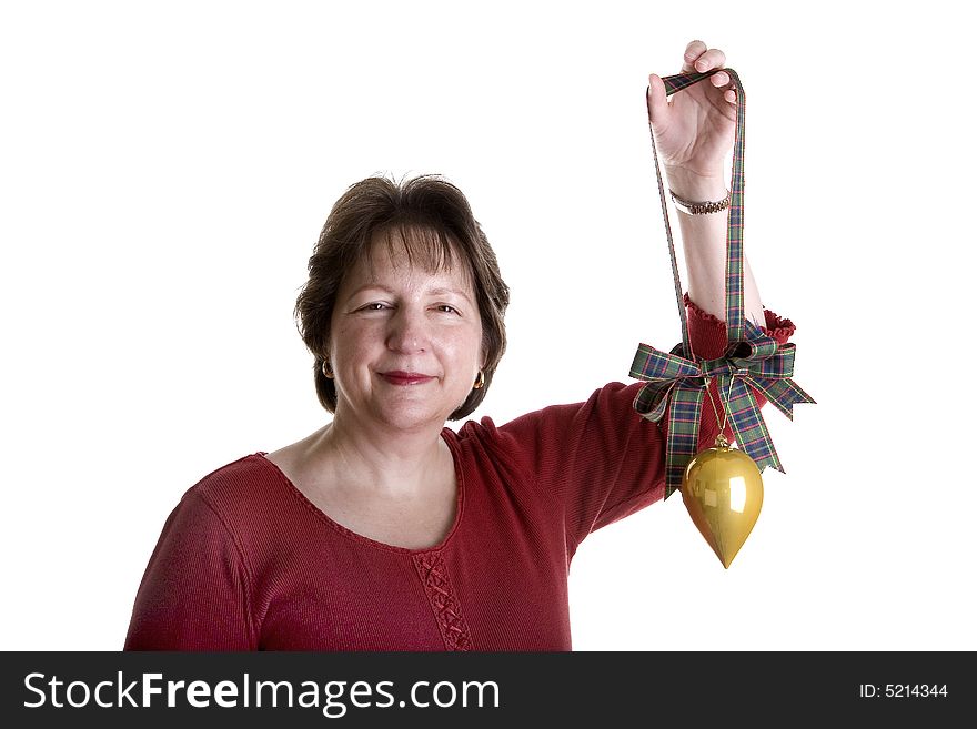 An attractive middle aged woman in red holding up a gold Christmas ornament. An attractive middle aged woman in red holding up a gold Christmas ornament