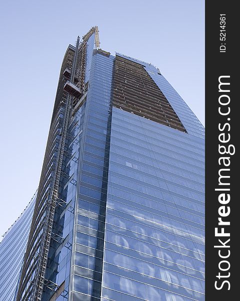 A new modern blue glass tower under construction. A new modern blue glass tower under construction