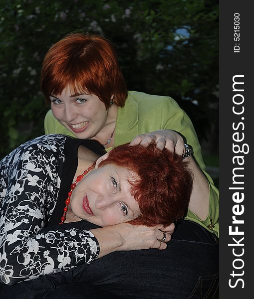 Senior woman laying on her daughter's lap and laughing. Senior woman laying on her daughter's lap and laughing