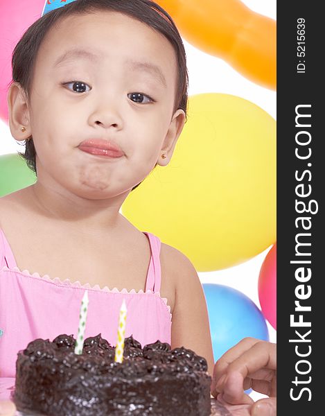 Birthday girl holding cake with the colorful balloons