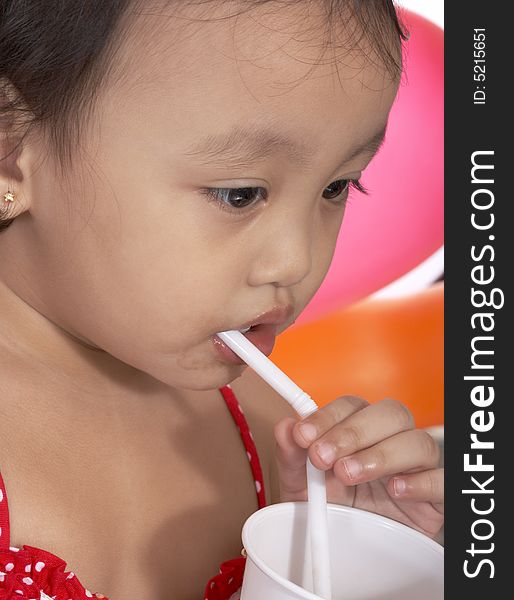 Child sipping juice on a white plastic cup