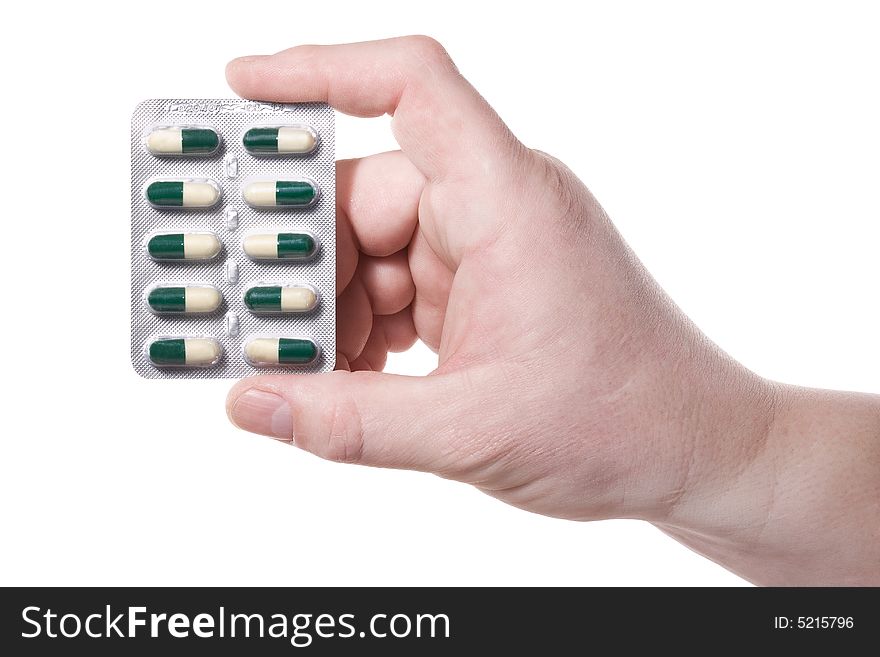 Hand holds a package with green-white pills. Isolated on white [with clipping path]. Hand holds a package with green-white pills. Isolated on white [with clipping path].