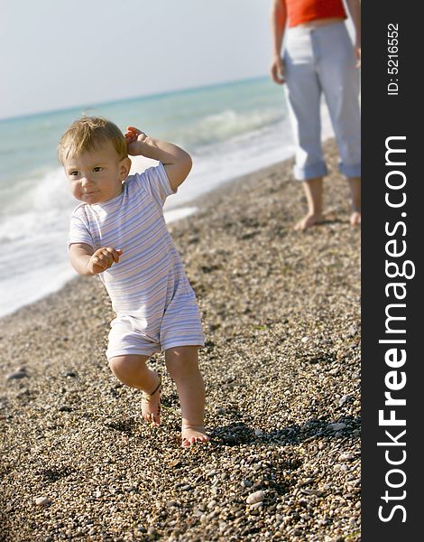 Baby going away from mother on beach. Baby going away from mother on beach