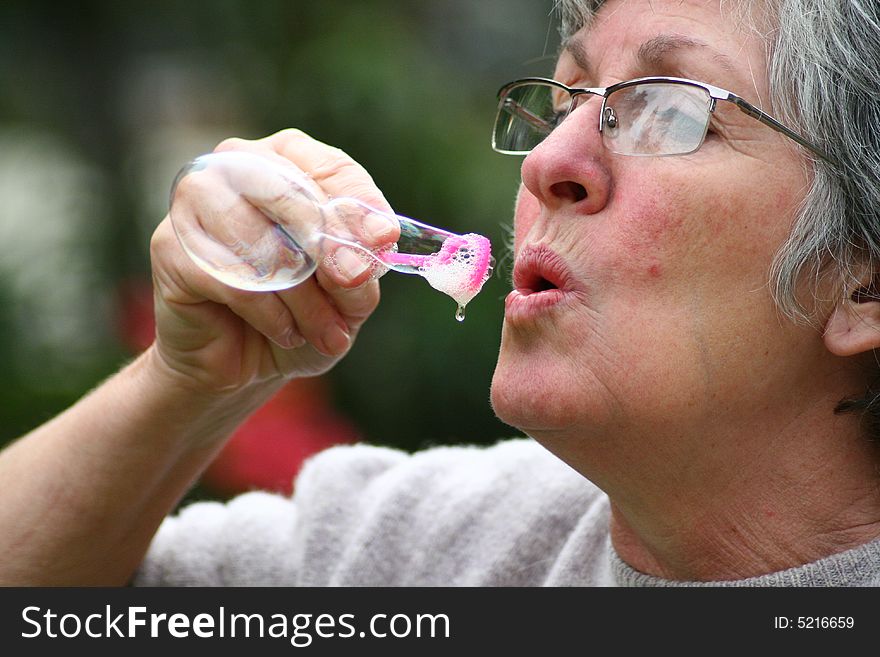 A white caucasian woman blowing bubbles. A white caucasian woman blowing bubbles