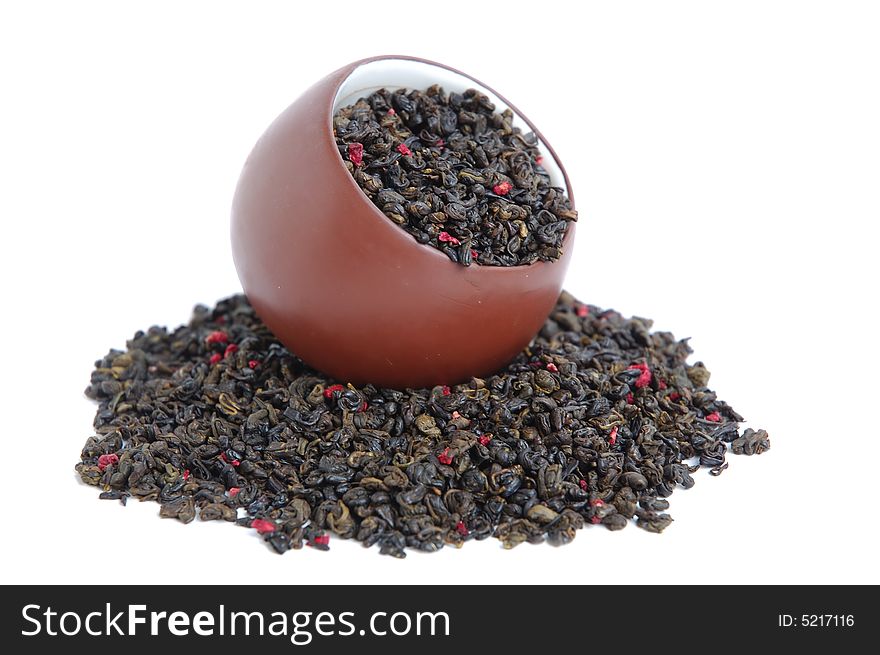 Cup of dried green tea leaves with red flower petal