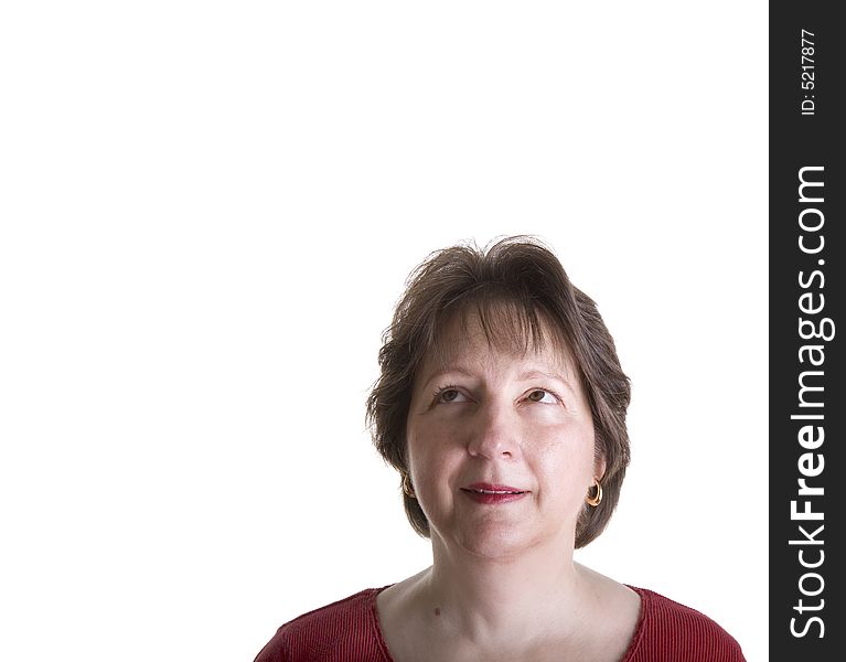 An attractive middle aged woman in red looking up and to the right into copy space. An attractive middle aged woman in red looking up and to the right into copy space