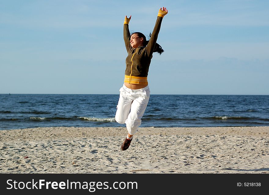 Attractive woman jumping on the sunny beach. Attractive woman jumping on the sunny beach