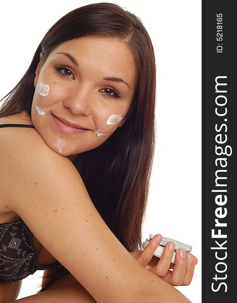 Attractive brunette woman applying cream on white background