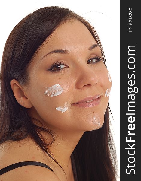 Attractive brunette woman applying cream on white background