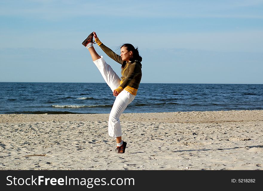 Attractive woman doing exercise on the beach