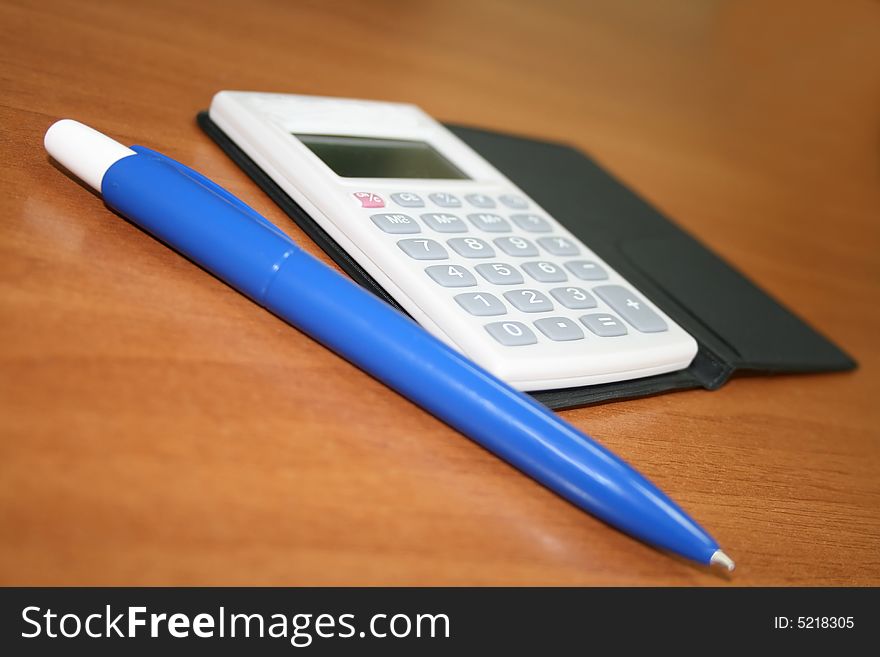 Blue pen and calculator on desk