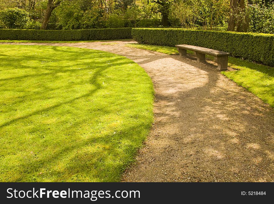 Bench and footpath in romantic garden