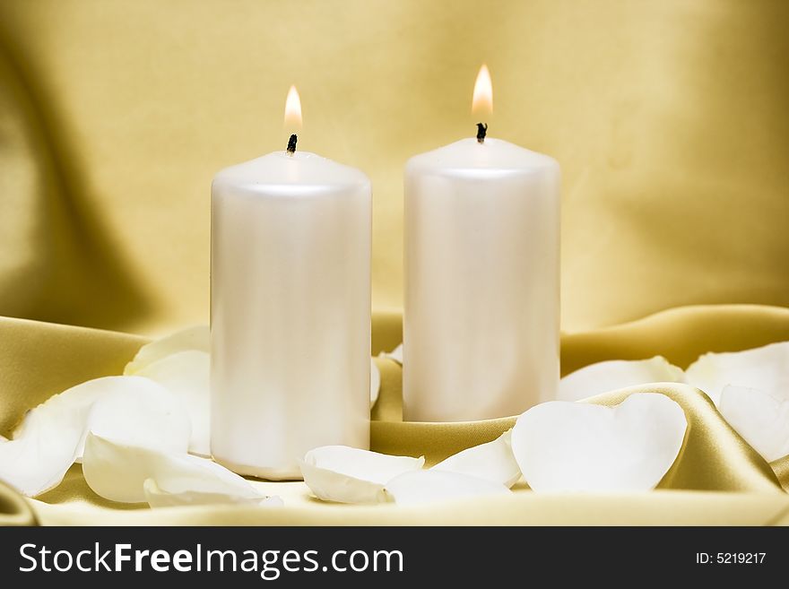 Candles with flower on golden background